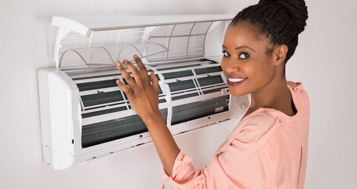woman opening air conditioner at home