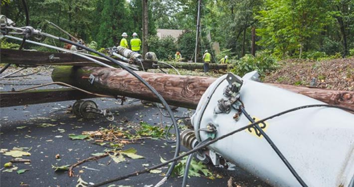 broken pole with transformer and fallen wires on ground