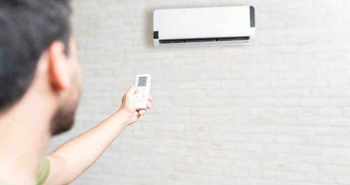 man with remote control for a heat pump