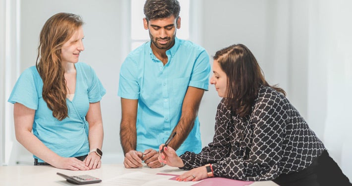 three people signing a housing agreement