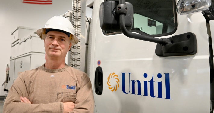 Unitil Employee Next to Company Truck