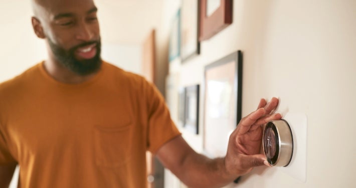 person adjusting thermostat