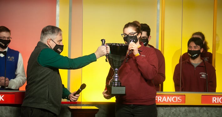 Unitil Media Relations Manager Alec O'Meara presents the championship trophy to Portsmouth High School coach Hannah Dul. (Photo credit: Mark Bolton Photography)