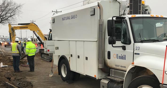 workers next to Unitil truck supervising ground excavation