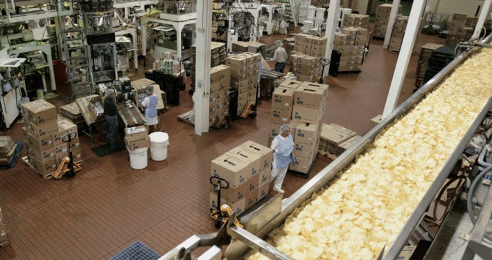 interior of UTZ factory showing workers boxing chips near conveyor belt