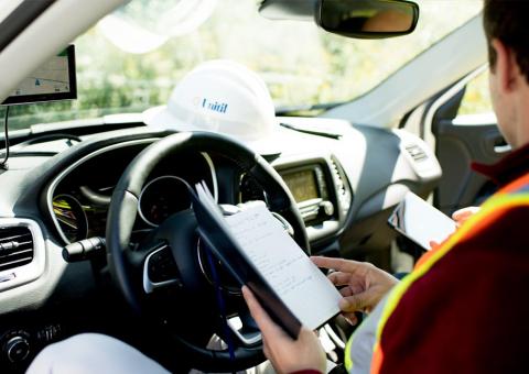 interior of Unitil truck with worker in driver's seat reviewing notebook
