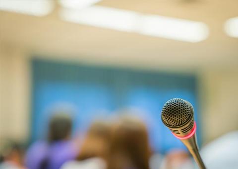 closeup of microphone with blurred people in the background